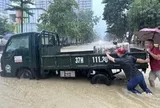 Phố thành 'sông' sau mưa lớn, dân Vinh hò nhau đẩy ô tô chết máy