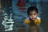 Người dân đắp ‘đê’ trước cửa nhà, trẻ em bơi giữa dòng triều cường đạt đỉnh tại TP.HCM