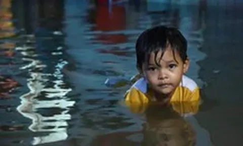 Người dân đắp ‘đê’ trước cửa nhà, trẻ em bơi giữa dòng triều cường đạt đỉnh tại TP.HCM