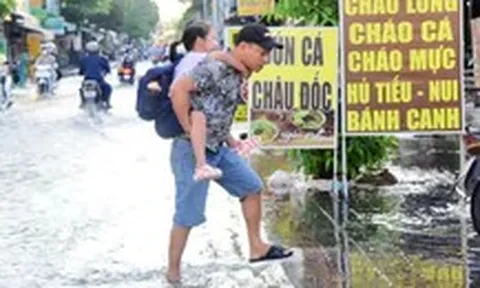 Ngập vì triều cường, người dân ở đường Bùi Văn Ba, TP.HCM cặm cụi dọn nhà từ sáng sớm